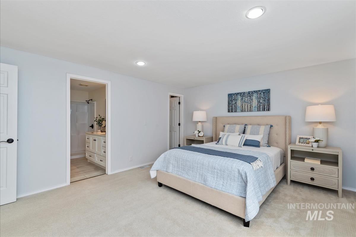 Bedroom featuring light colored carpet, connected bathroom, and recessed lighting