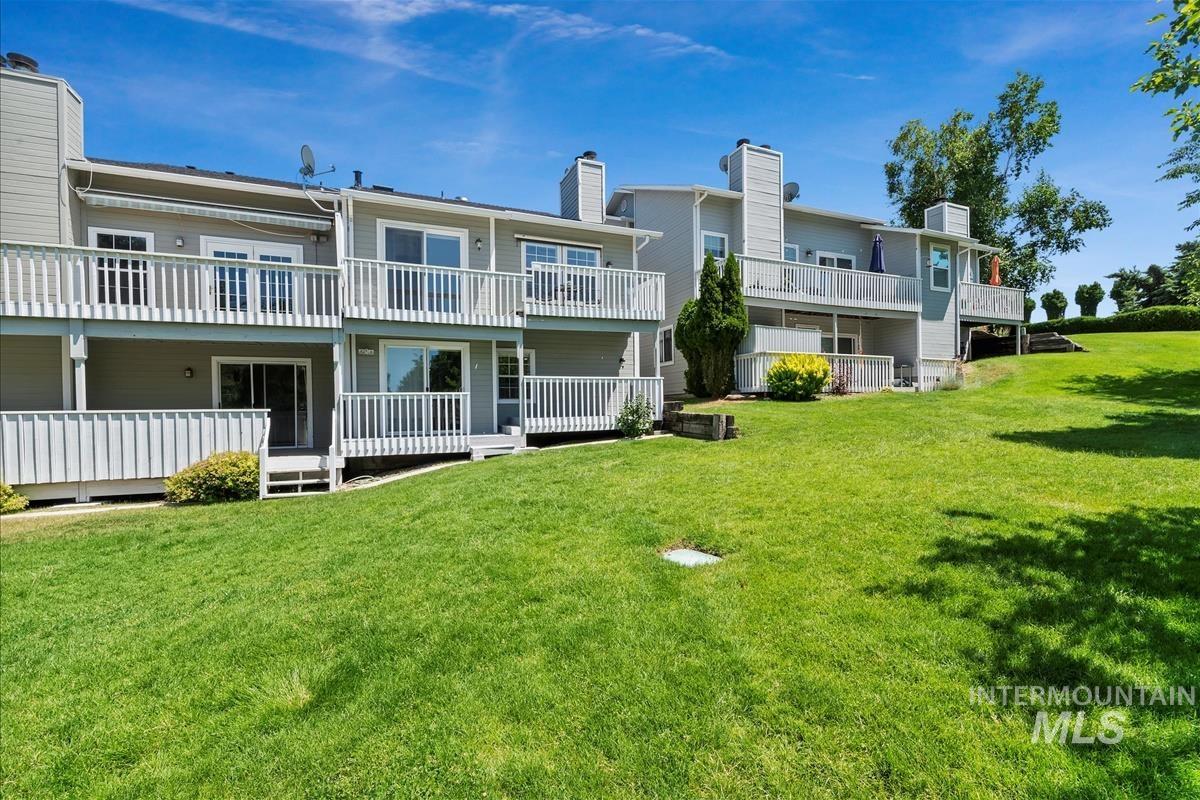 Rear view of property with a chimney and a yard
