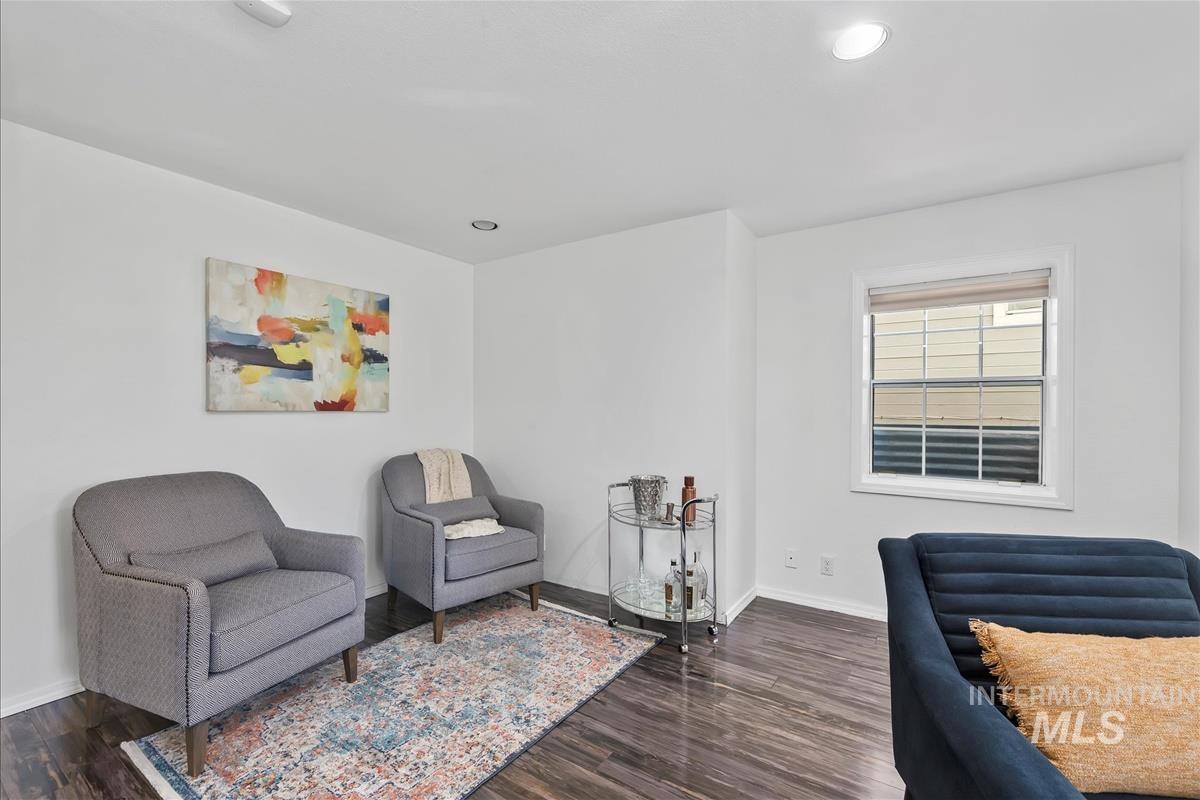 Living area featuring dark wood-style flooring and recessed lighting