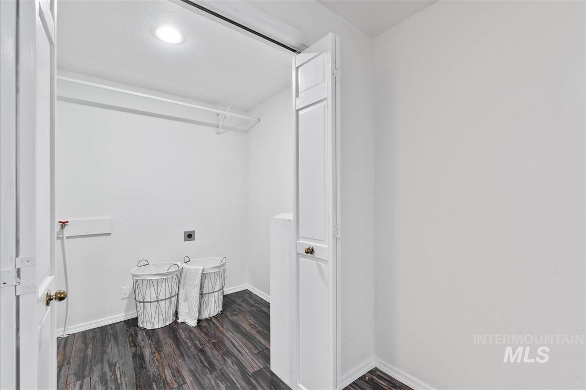 Laundry area with electric dryer hookup and wood finished floors