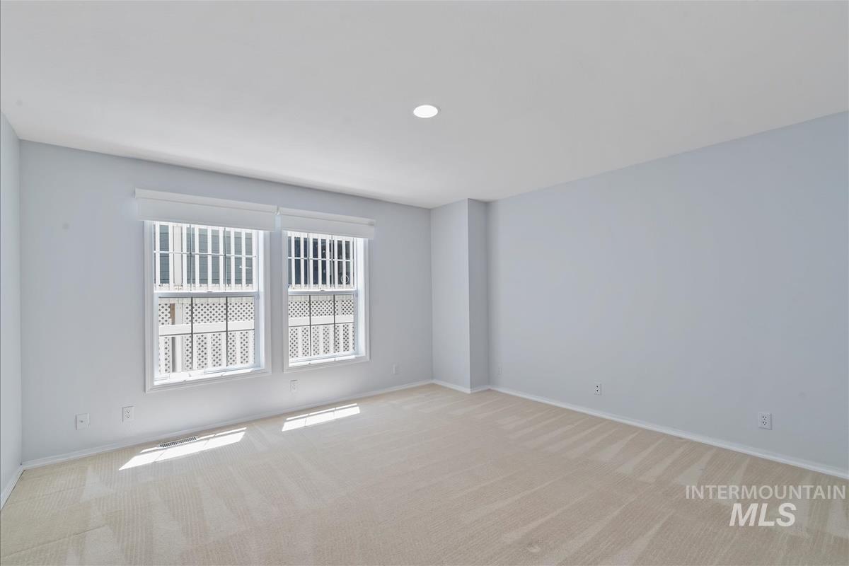 Empty room featuring light carpet