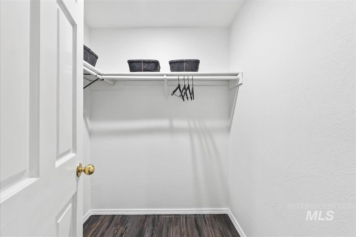 Walk in closet featuring dark wood-style flooring
