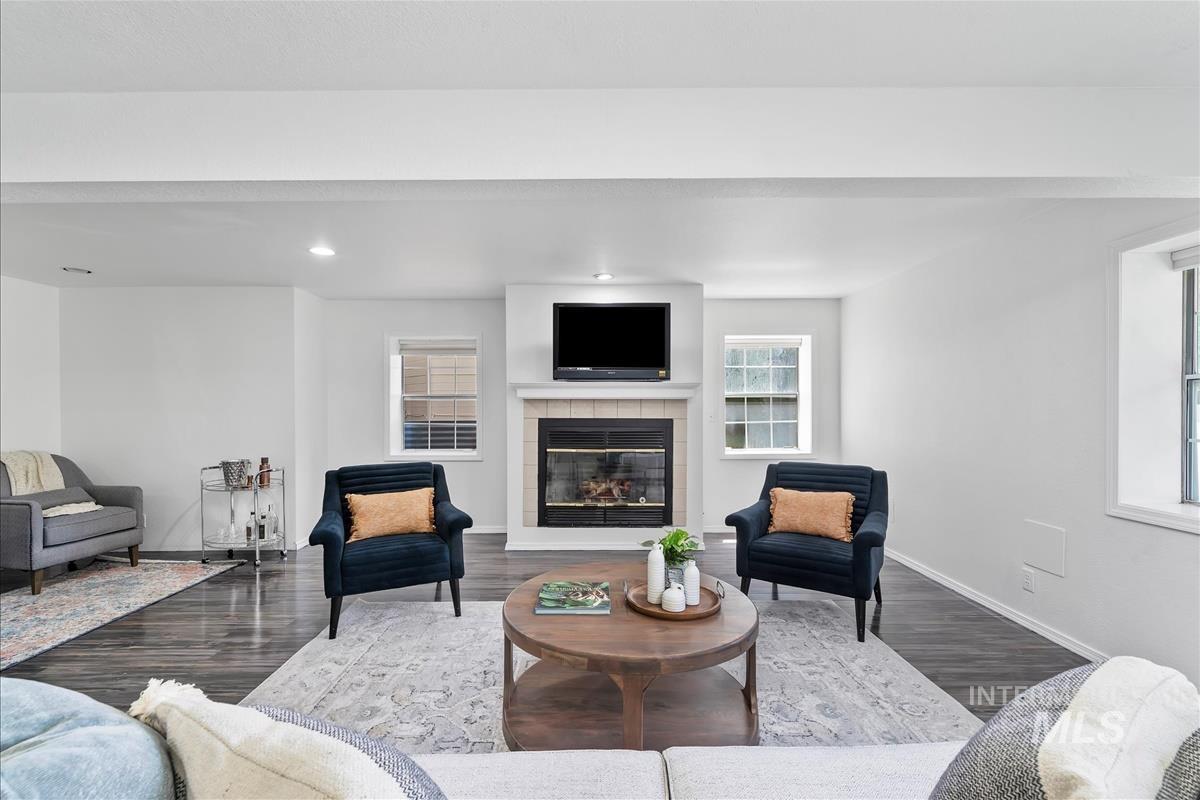 Living room featuring dark wood finished floors, a fireplace, and recessed lighting