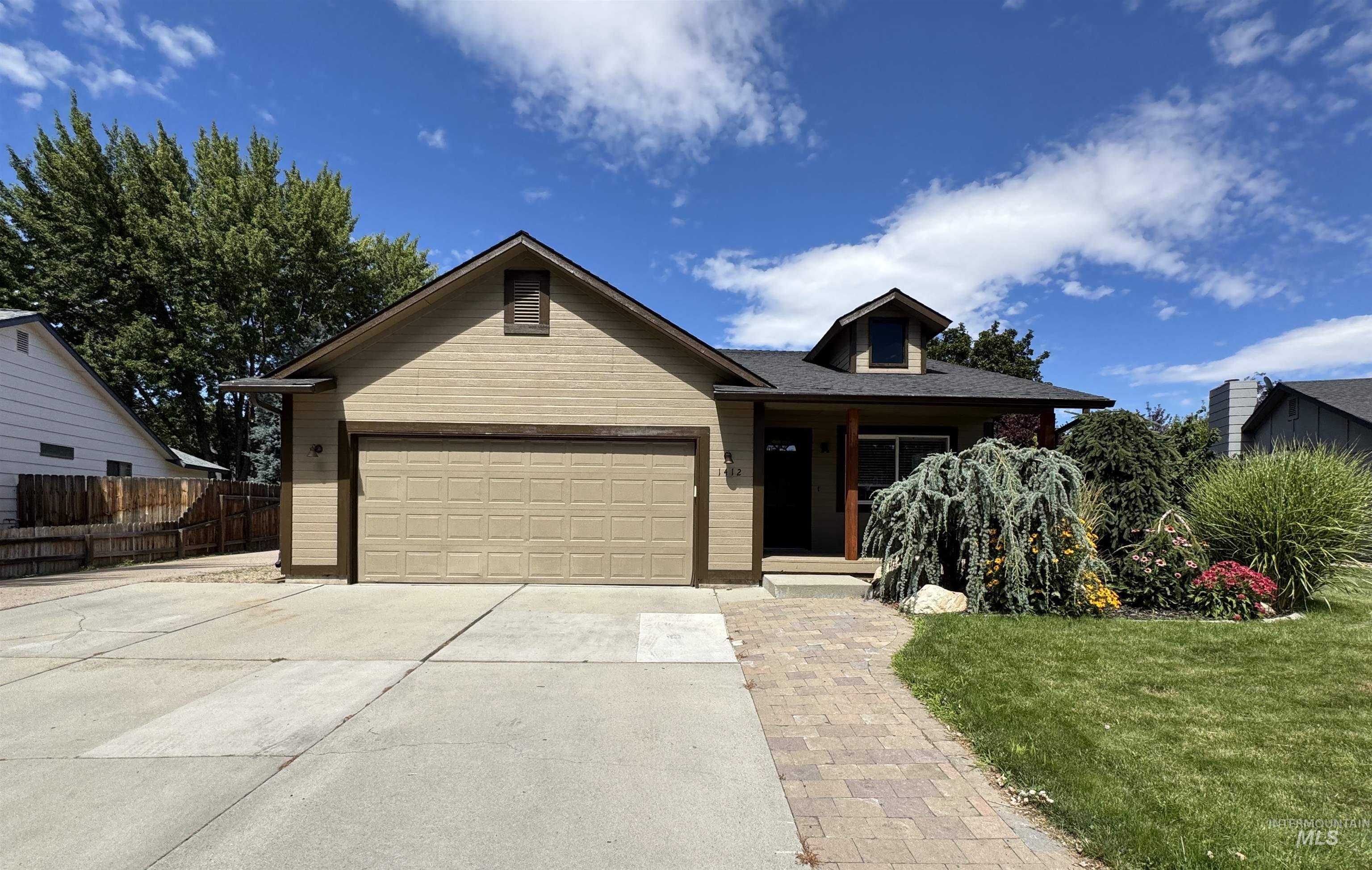 Single story home with concrete driveway and a garage