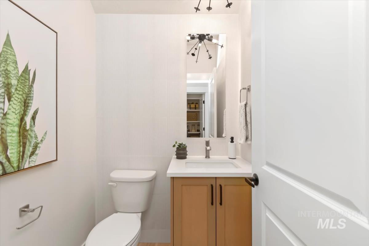 Half bathroom with vanity and tile walls