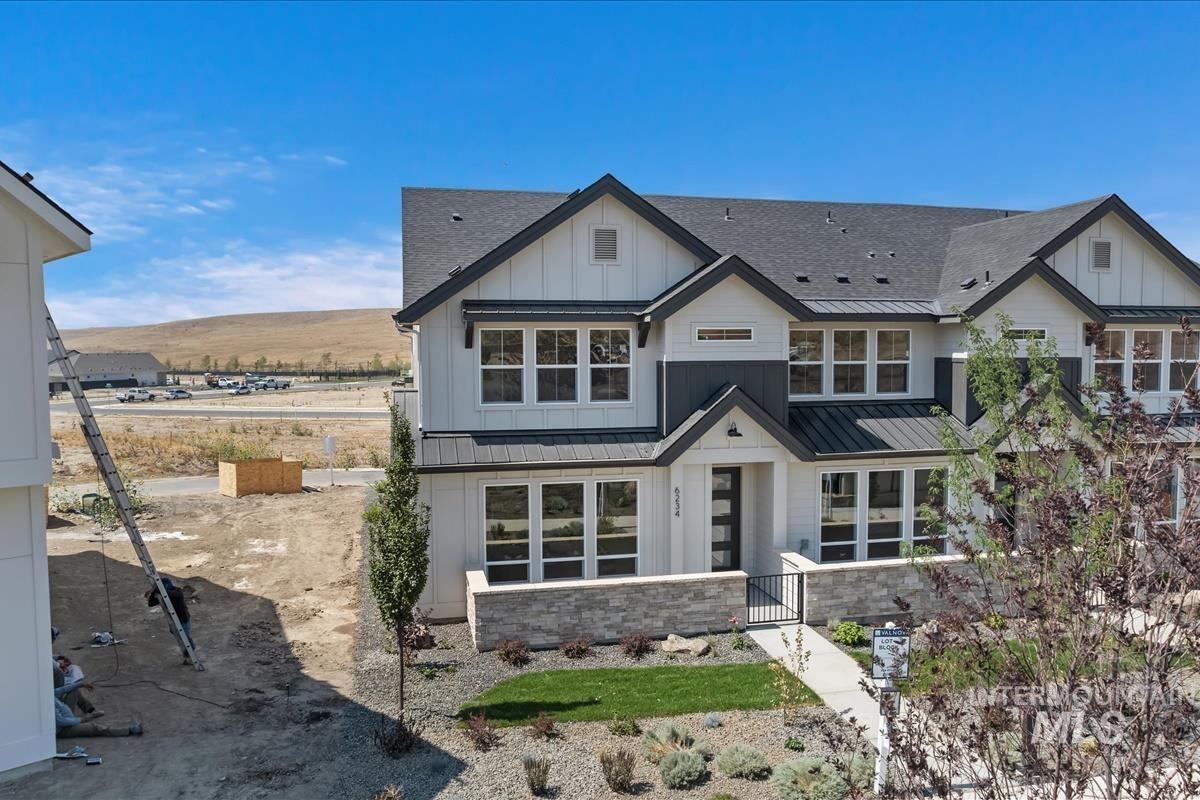 Modern farmhouse with roof with shingles, board and batten siding, a standing seam roof, and a metal roof