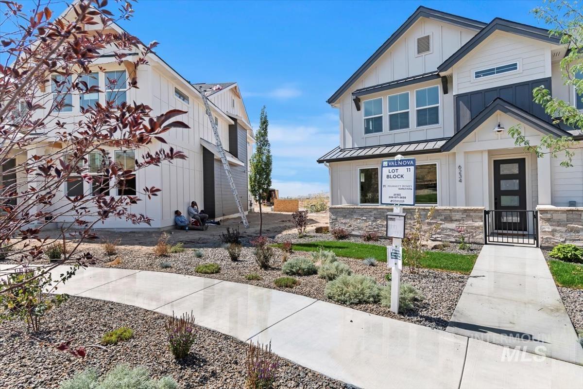Modern farmhouse featuring board and batten siding, a standing seam roof, a metal roof, and stone siding