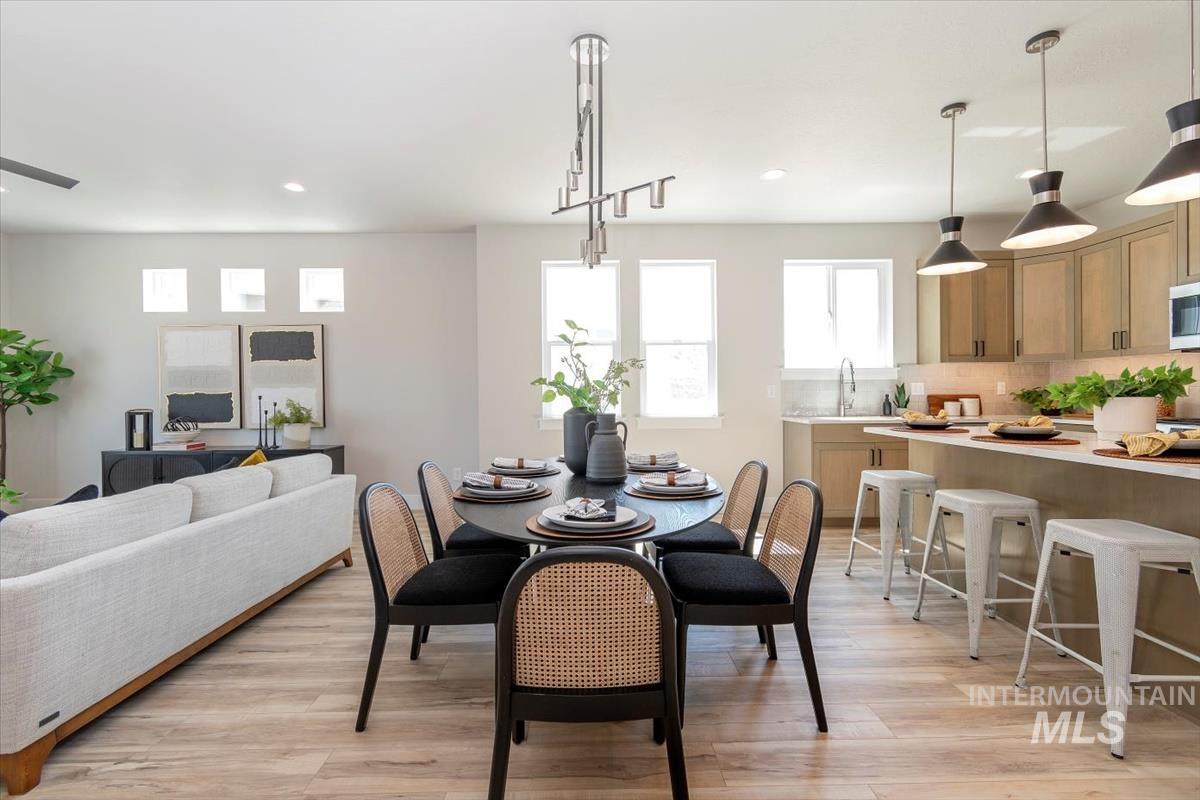 Dining area with light wood-style flooring and recessed lighting