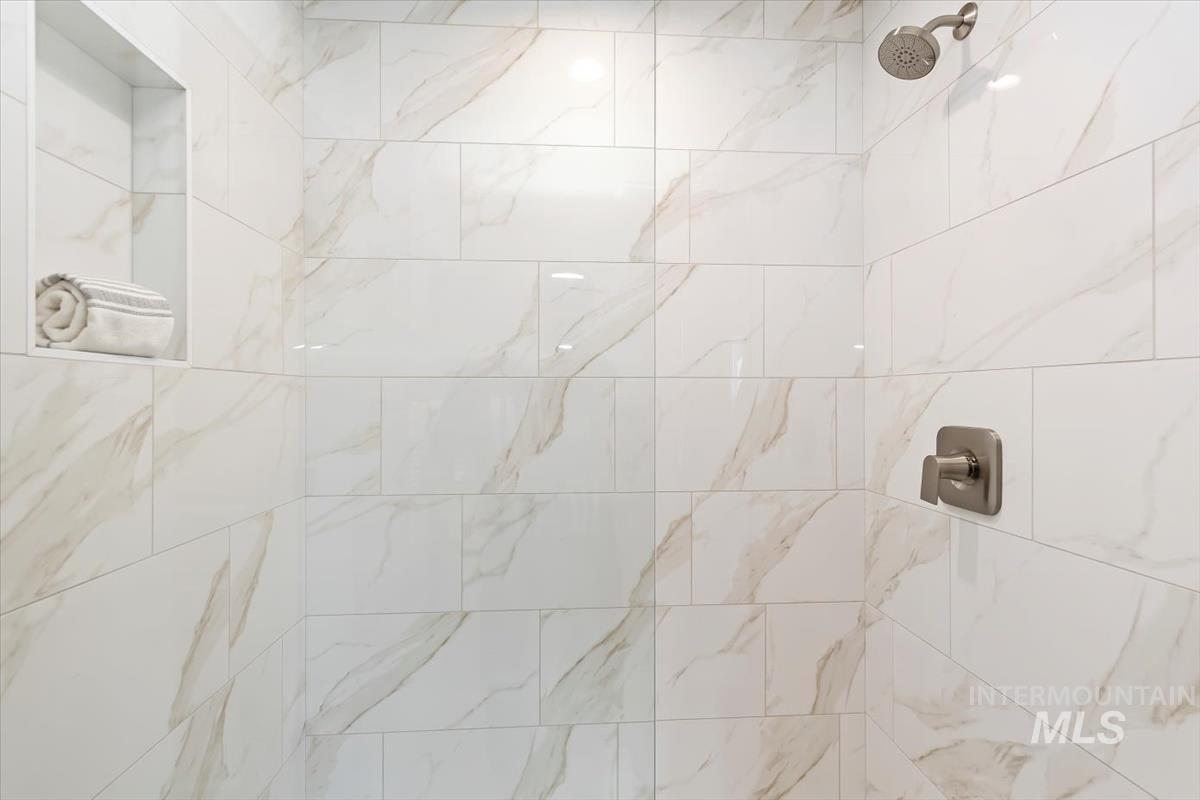 Full bath featuring a tile shower