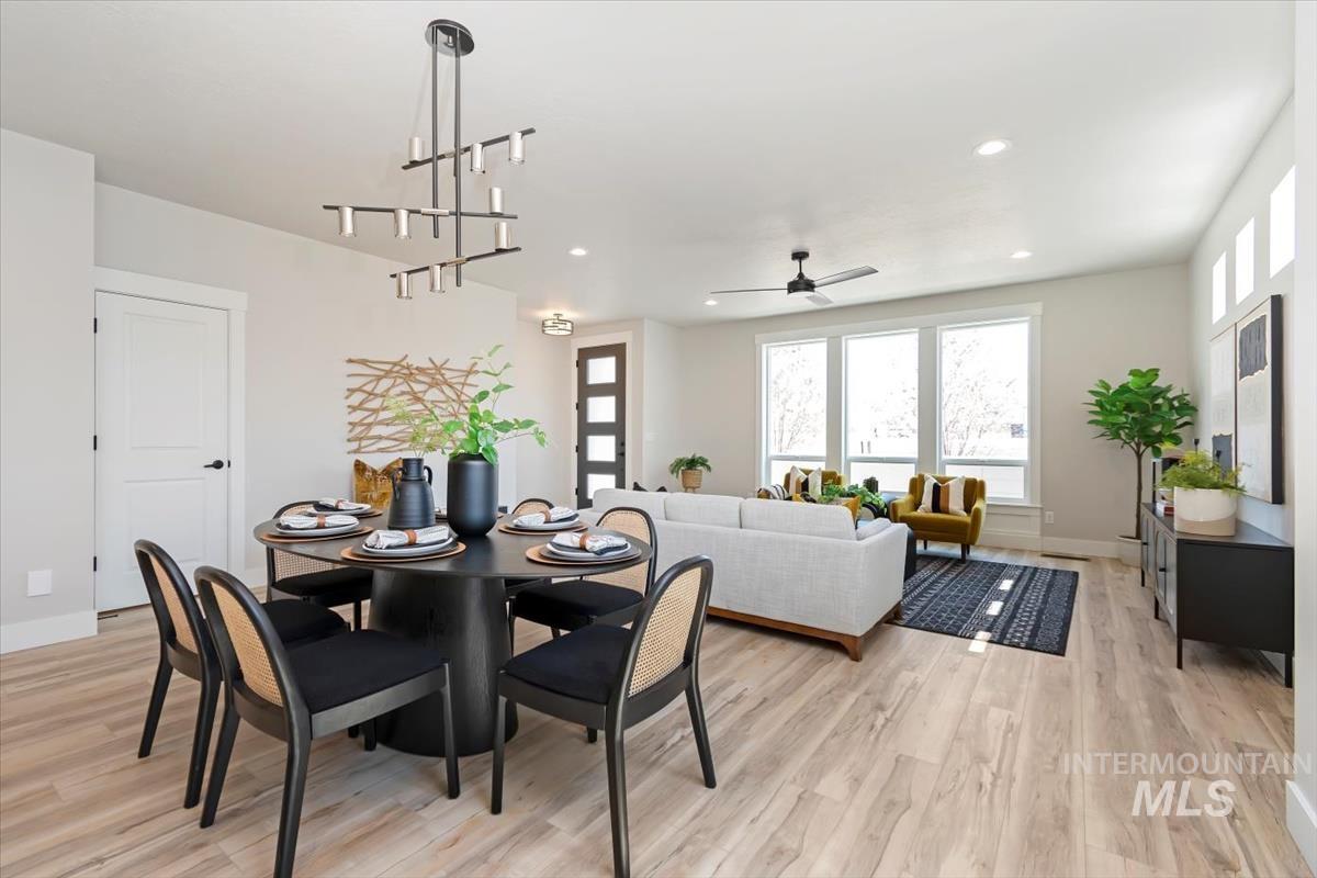 Dining space with a ceiling fan, recessed lighting, light wood-style floors, and a chandelier