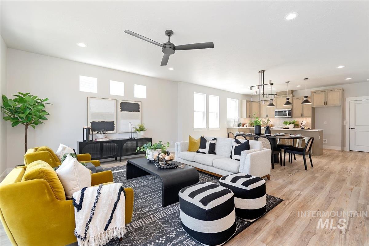 Living room featuring light wood-style flooring, recessed lighting, and ceiling fan
