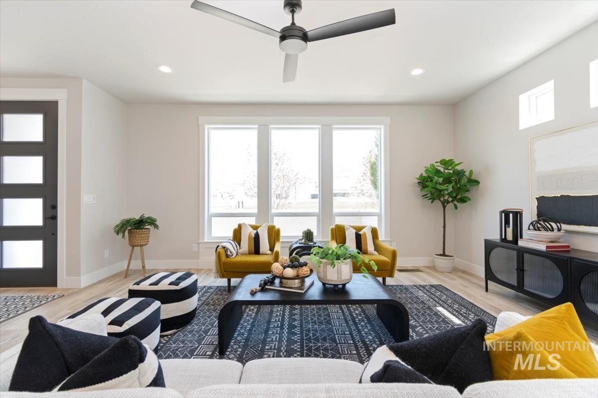 Living room with plenty of natural light, light wood-style floors, recessed lighting, and ceiling fan