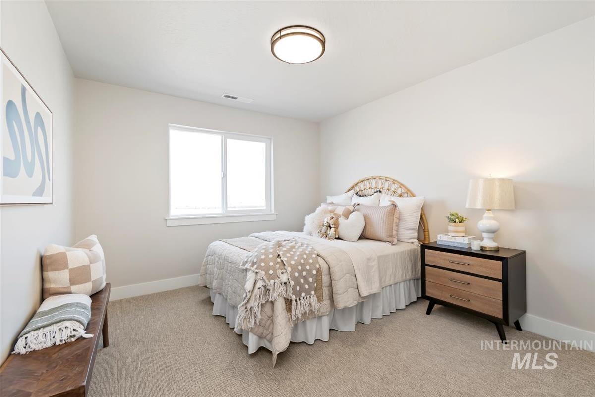 Bedroom featuring baseboards and light carpet