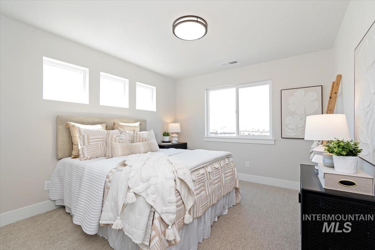 Bedroom featuring baseboards and light carpet
