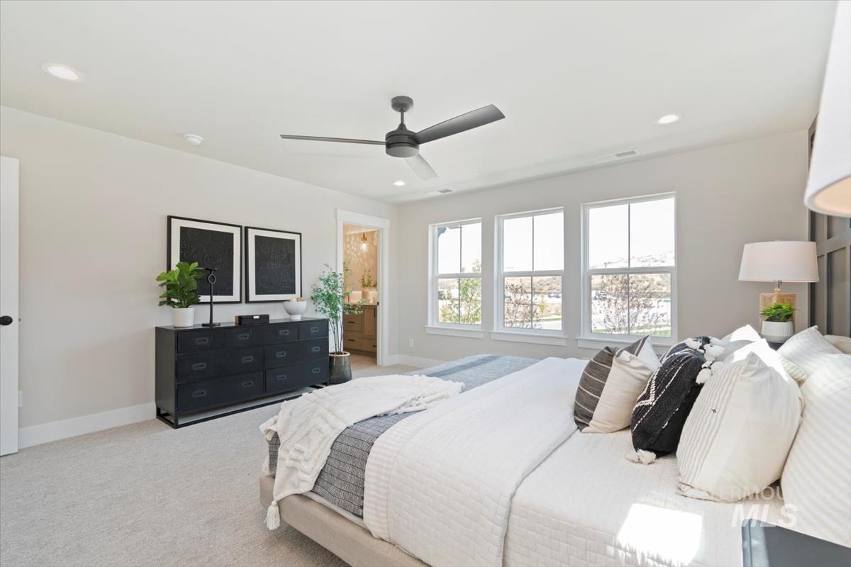 Carpeted bedroom featuring ceiling fan, recessed lighting, and ensuite bathroom