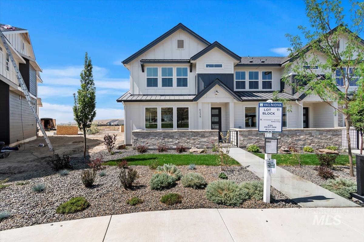 View of front facade with a standing seam roof, board and batten siding, and a metal roof