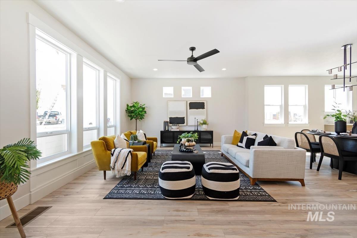 Living area featuring light wood-style floors, recessed lighting, and a ceiling fan