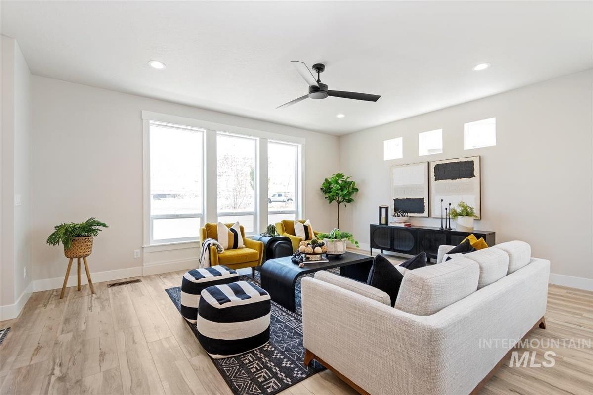 Living room featuring healthy amount of natural light, light wood-style floors, recessed lighting, and ceiling fan