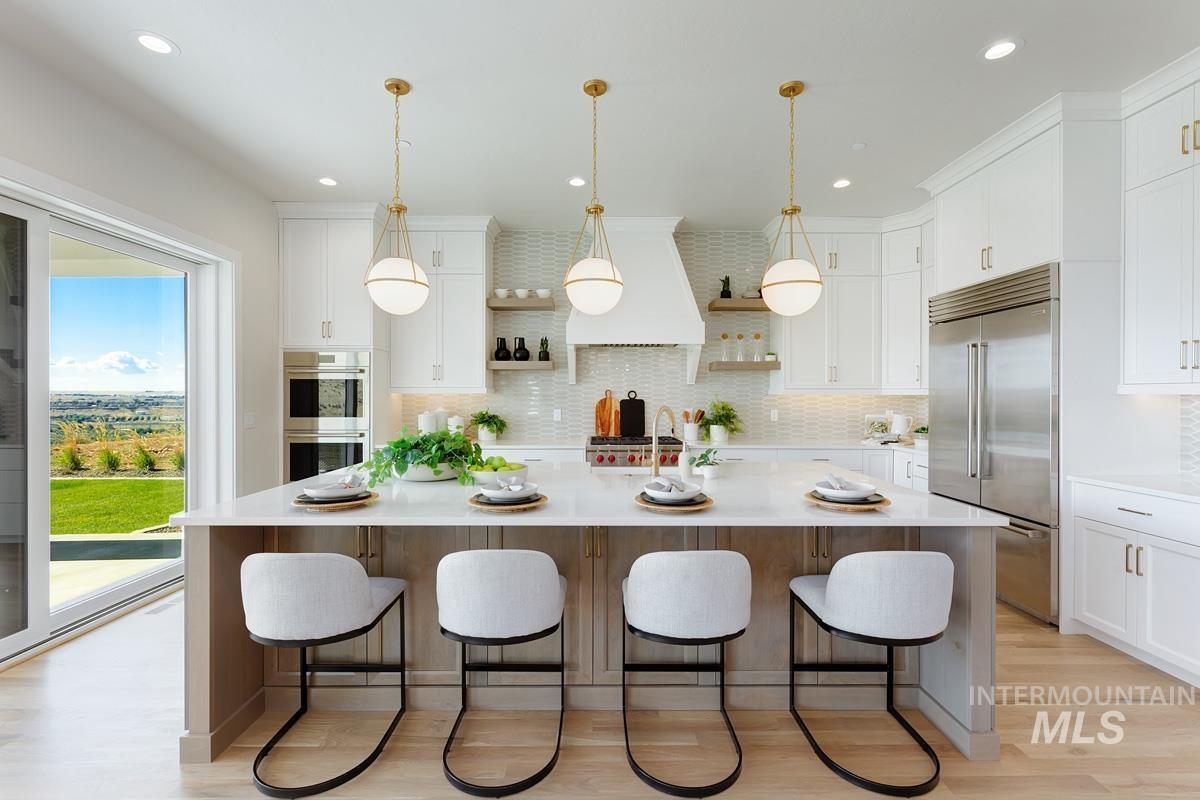 Kitchen featuring open shelves, decorative light fixtures, backsplash, a large island with sink, and stainless steel appliances