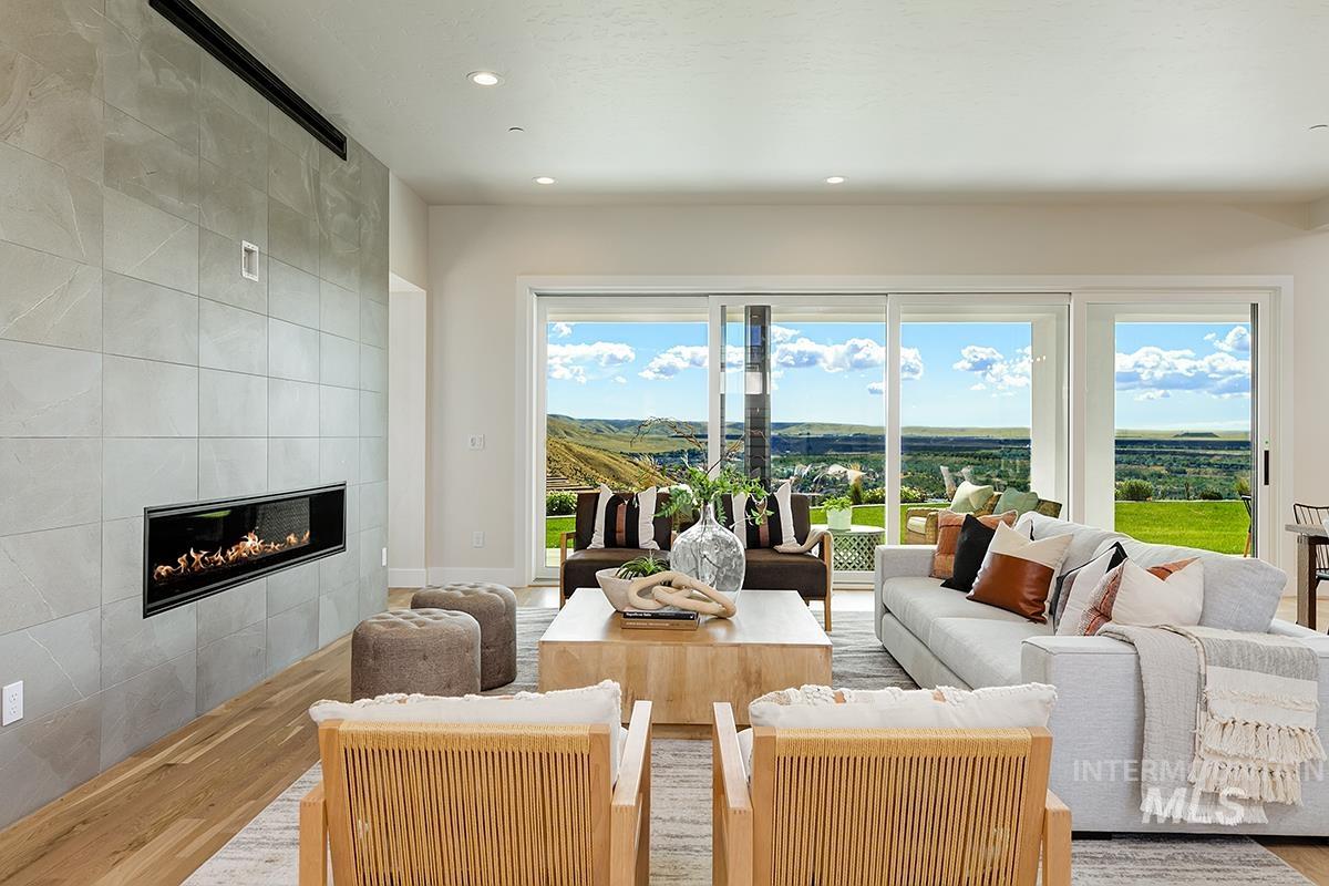 Living room with a fireplace, wood finished floors, and recessed lighting