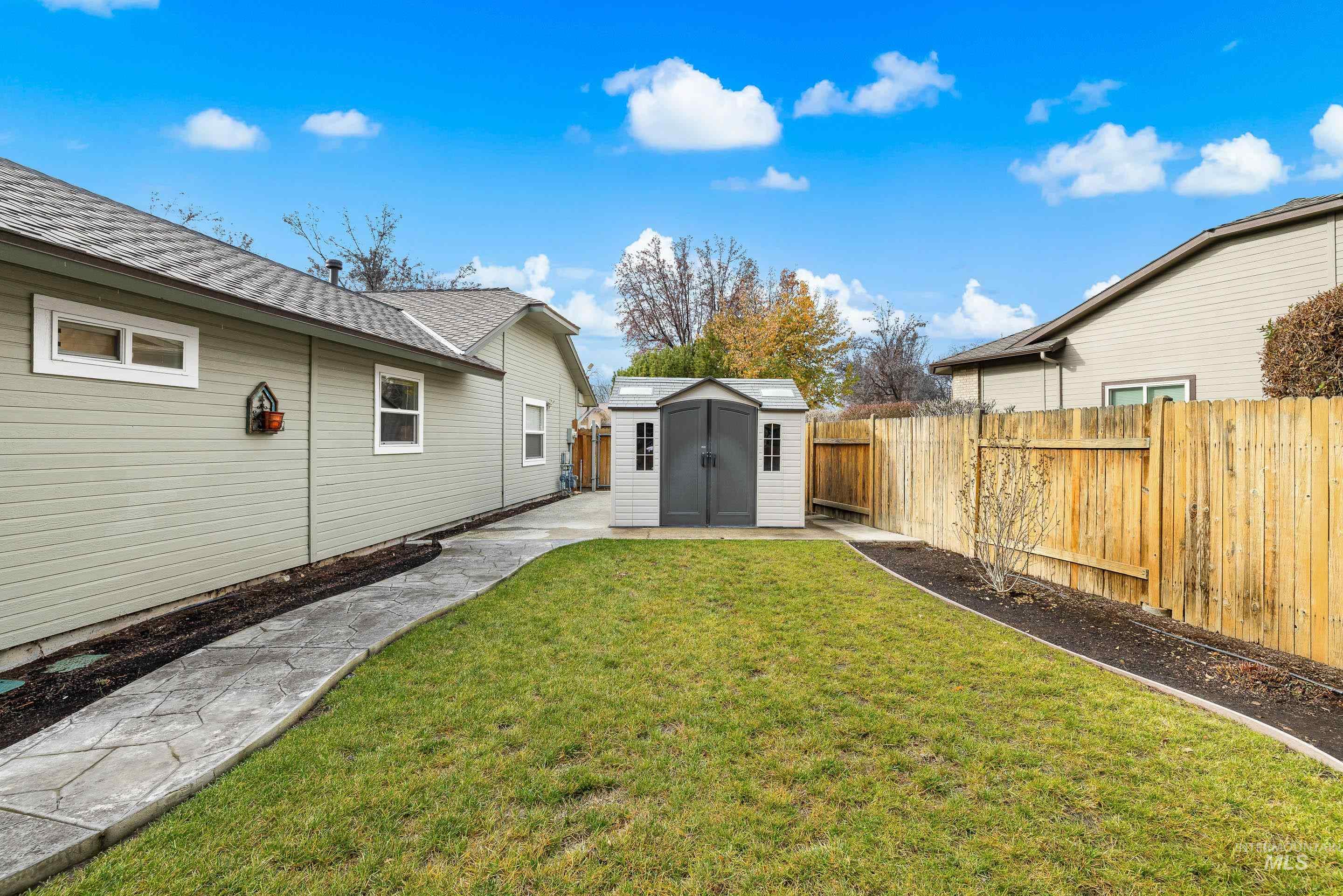 Fenced backyard with a storage shed and a patio area