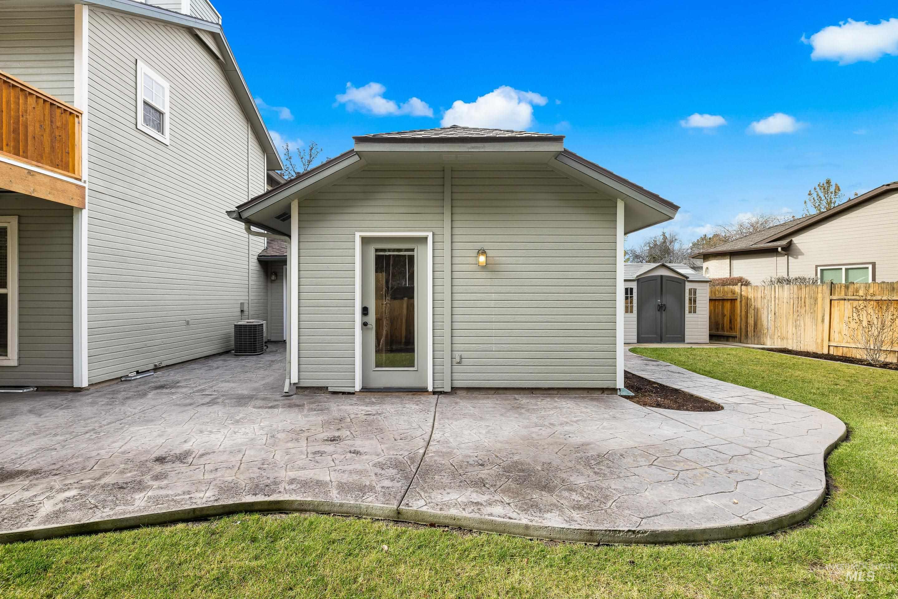 Rear view of house featuring a storage unit, a patio, and a fenced backyard