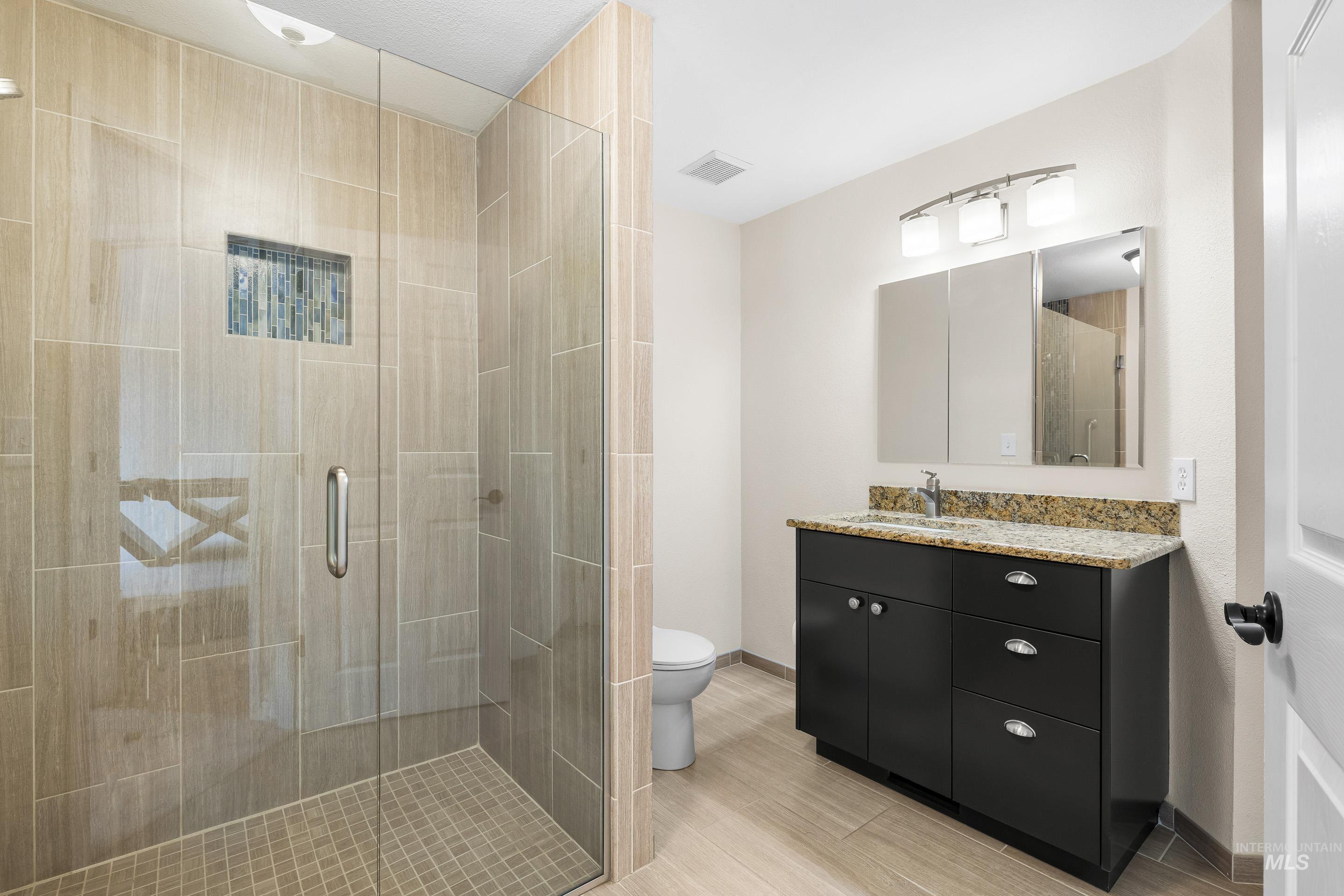 Bathroom with vanity and a stall shower