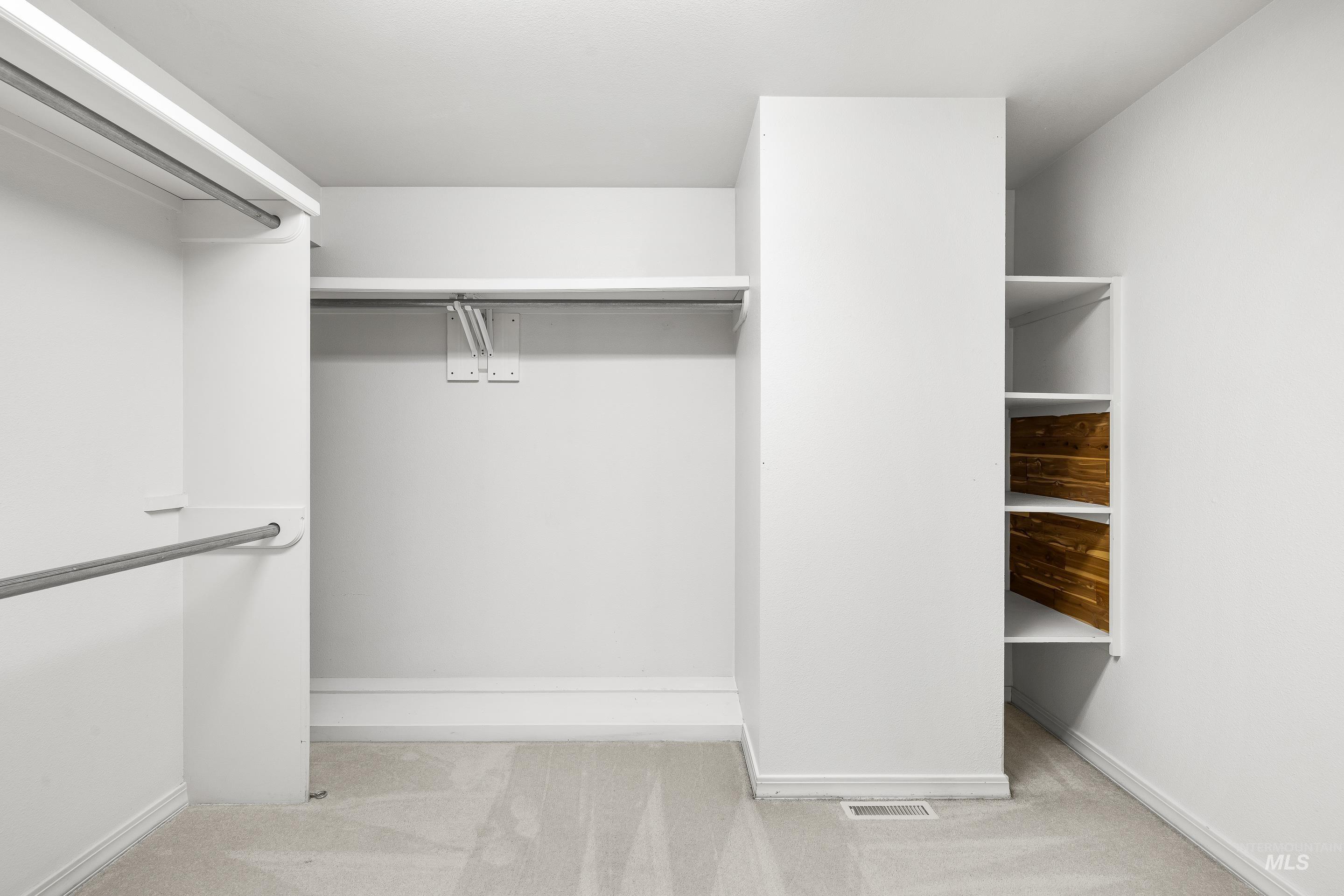 Spacious closet with light colored carpet