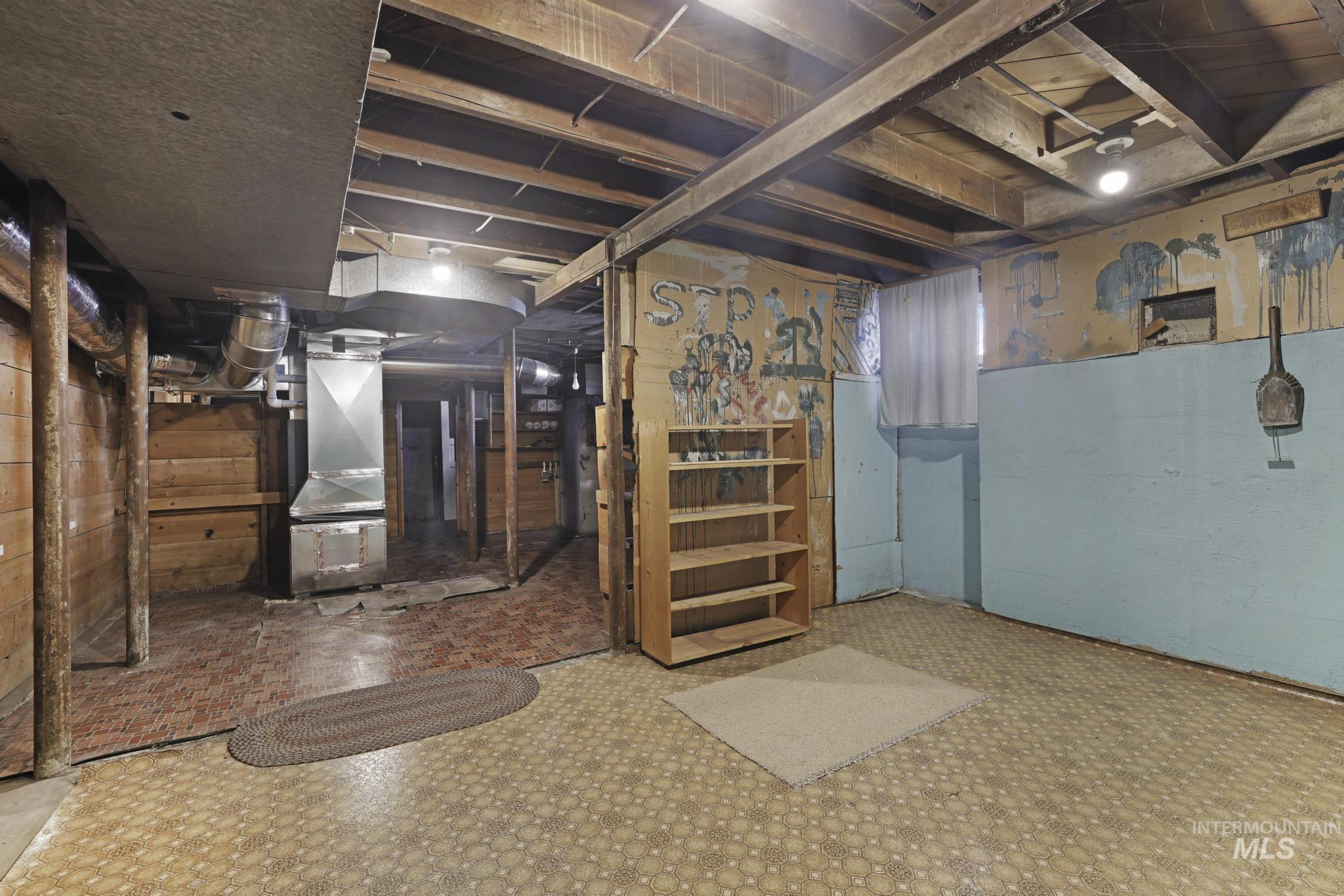 Unfinished basement with heating unit and tile patterned floors