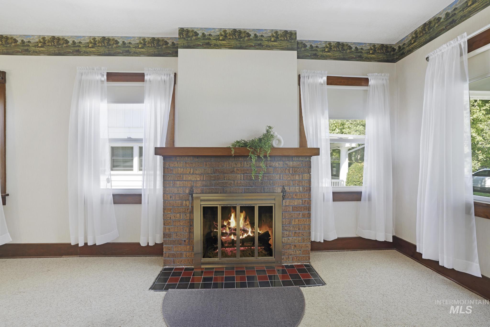 Living area featuring carpet flooring and a brick fireplace