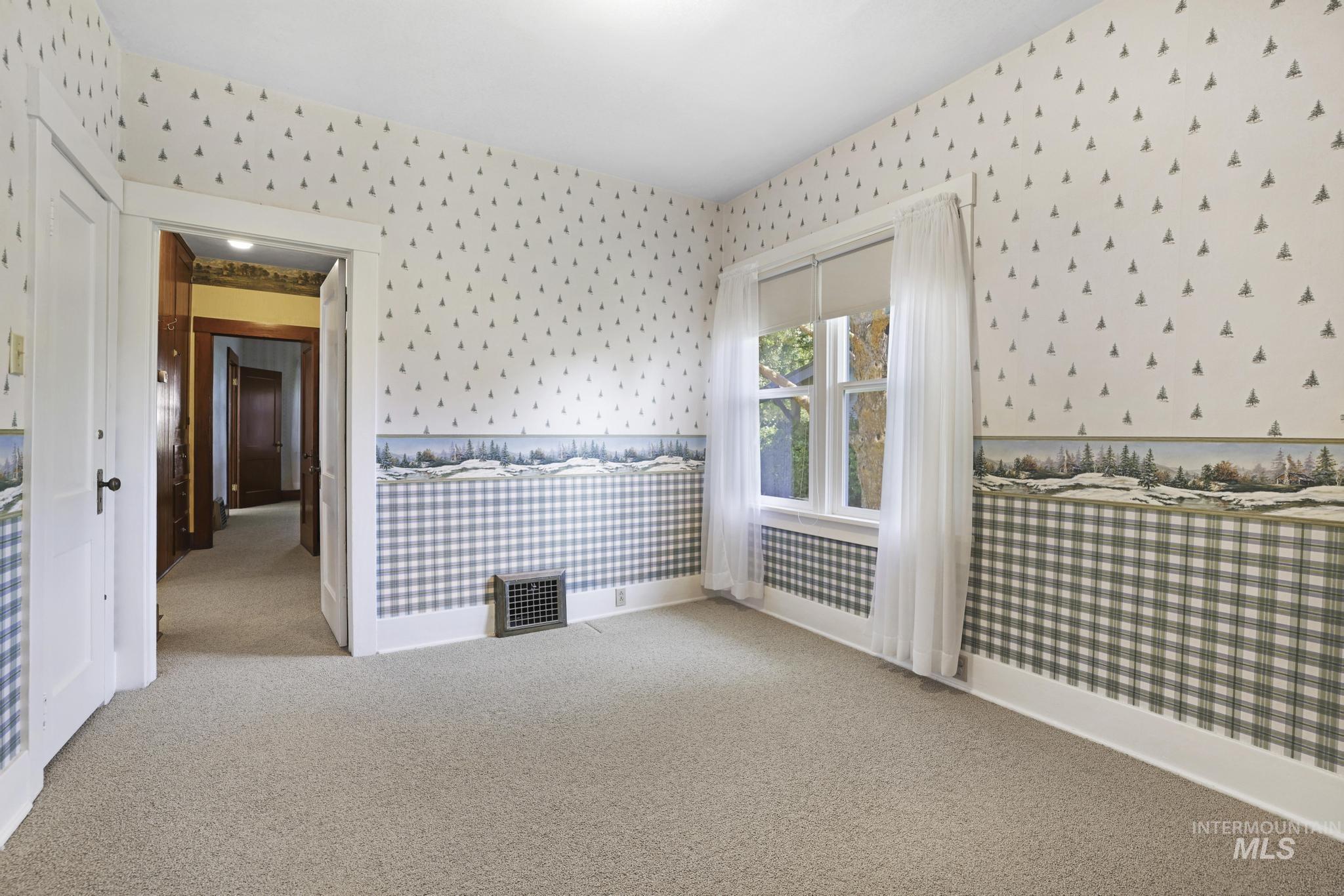 Spare room with light colored carpet and wallpapered walls