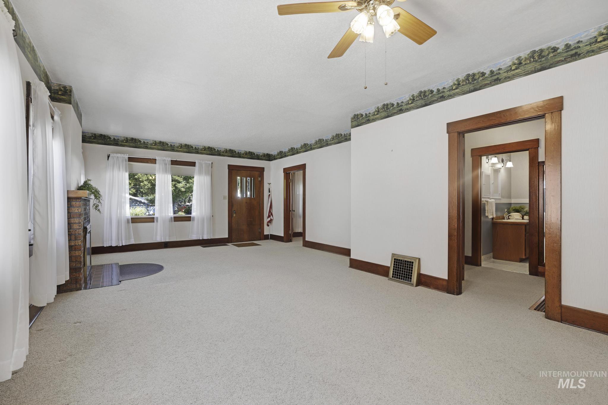 Unfurnished living room with carpet, ceiling fan, and french doors