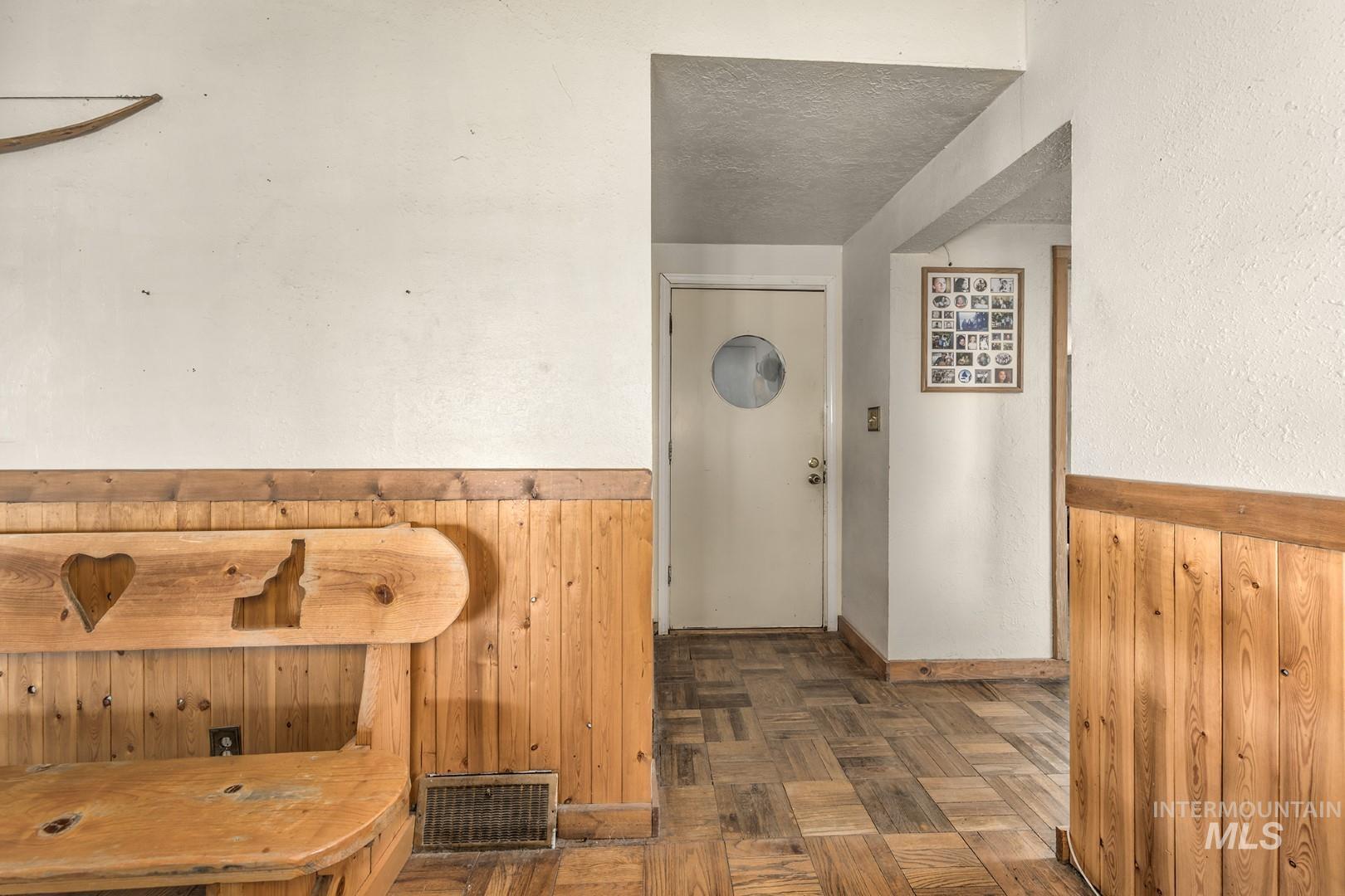 Hall with wood walls and a textured ceiling