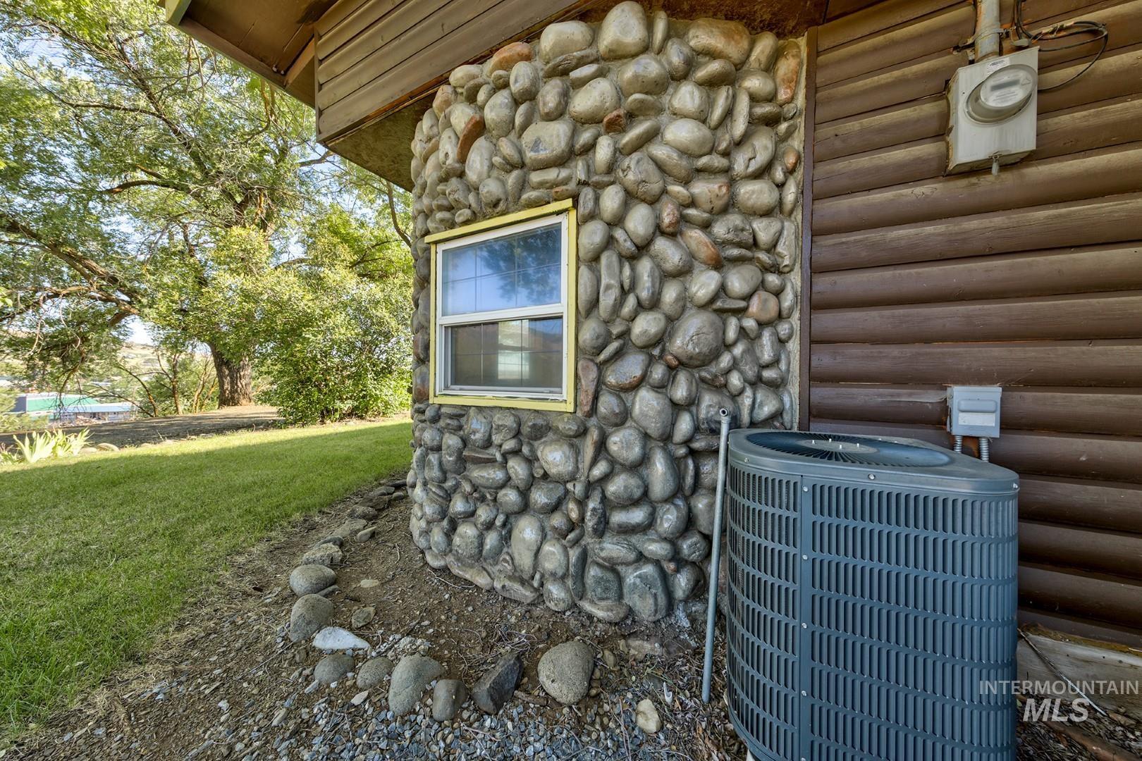 Exterior view of a central AC unit and faux log siding
