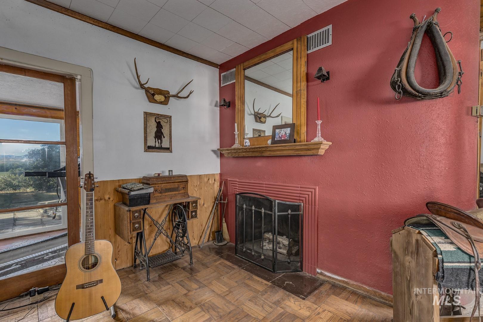 Living room with wood walls, a fireplace, and a wainscoted wall
