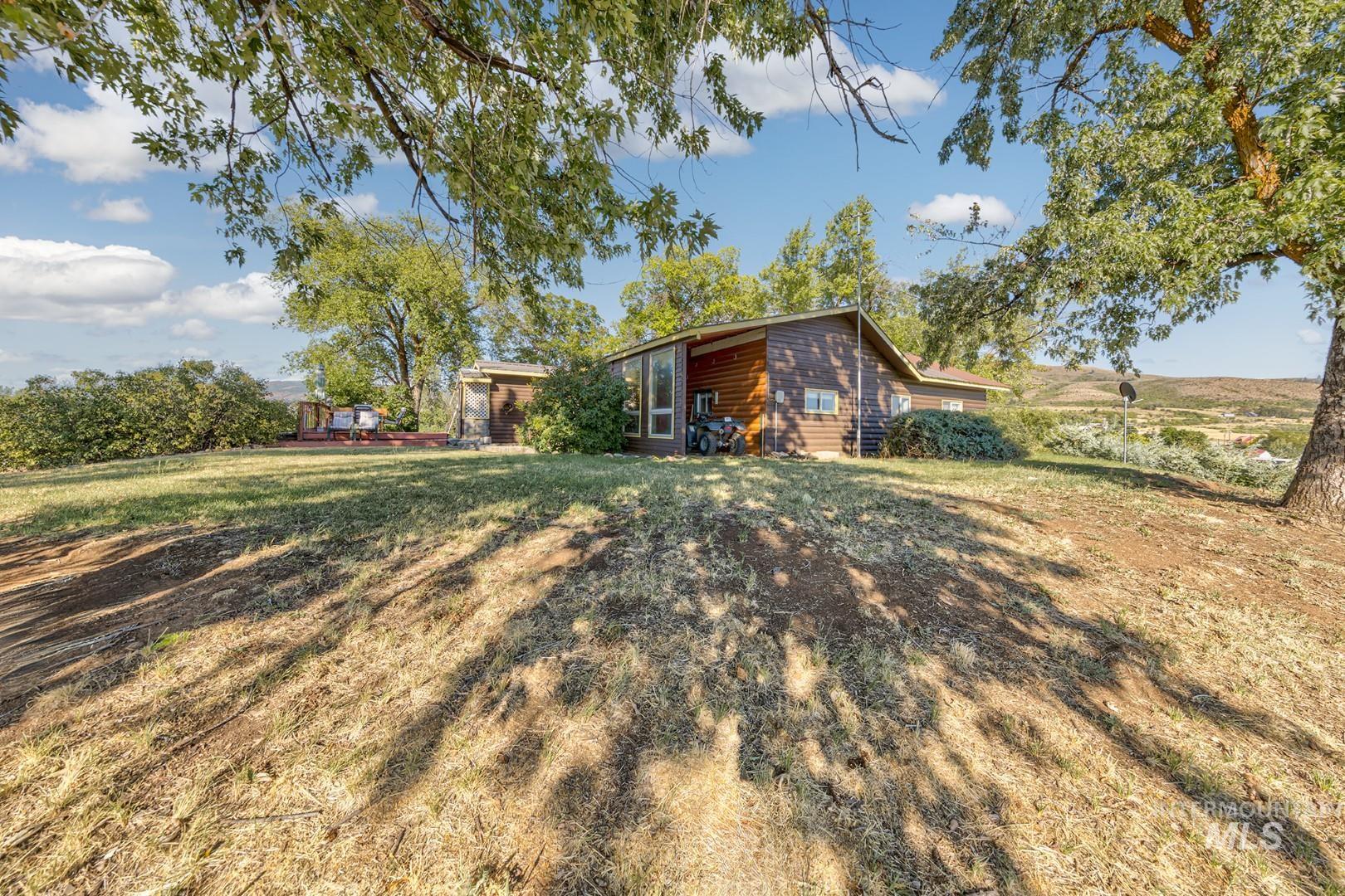 Rear view of house featuring a yard and faux log siding