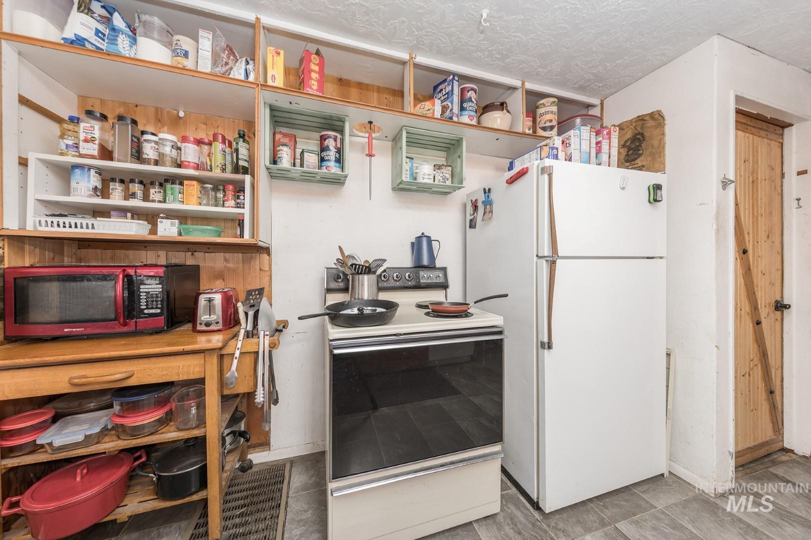 Kitchen featuring white appliances and a textured ceiling