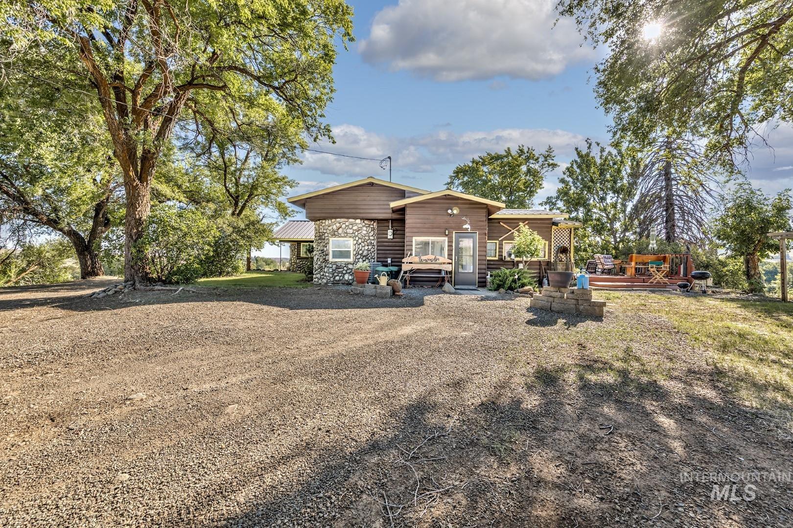Rear view of house featuring a wooden deck and stone siding