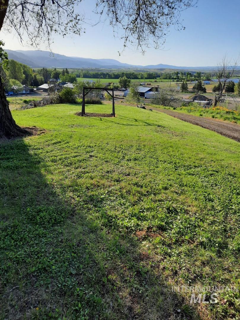 View of grassy yard with a mountain view and a rural view