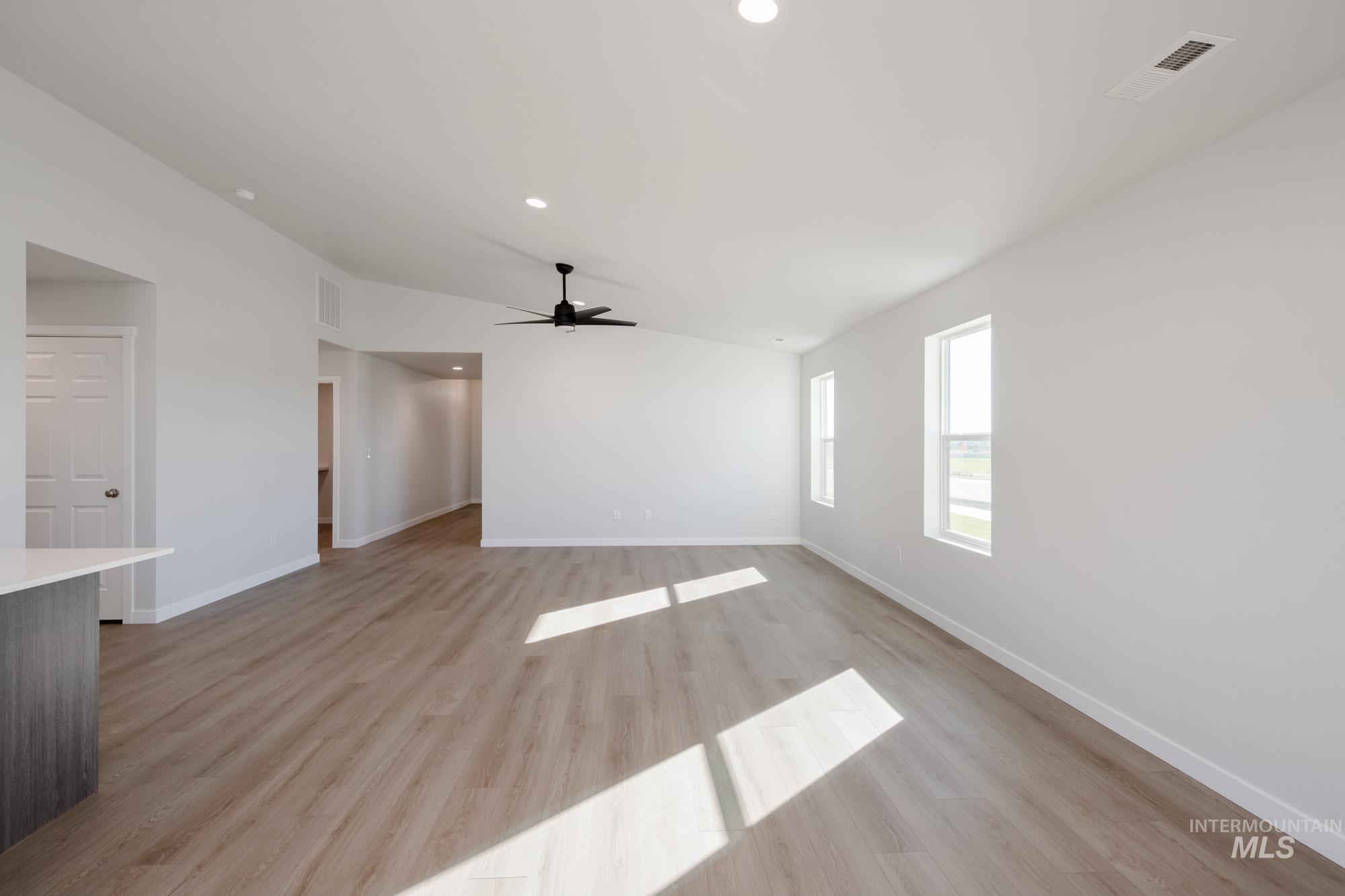 Unfurnished living room featuring vaulted ceiling, light wood finished floors, recessed lighting, and a ceiling fan
