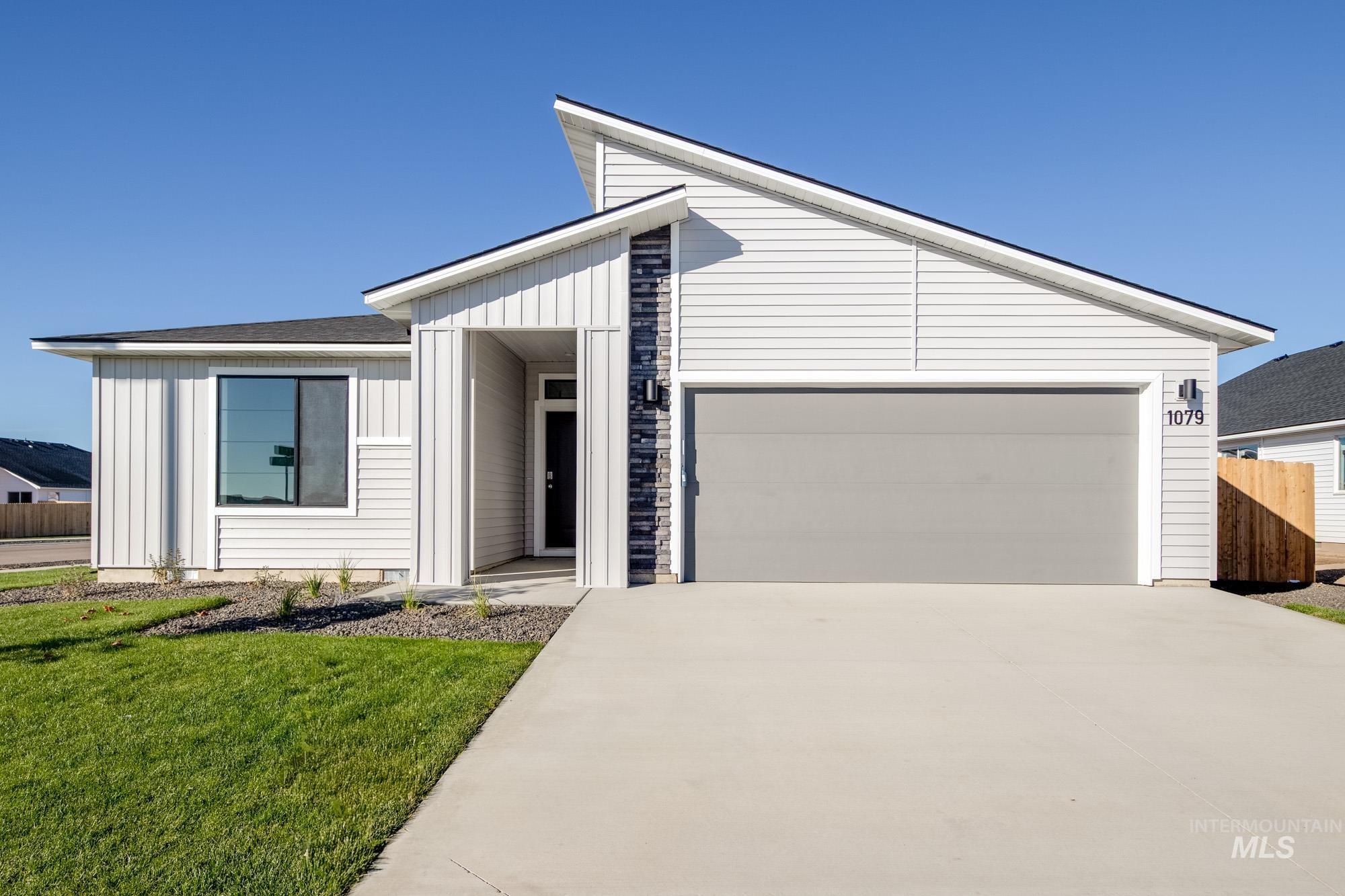 View of front facade featuring board and batten siding, concrete driveway, and an attached garage