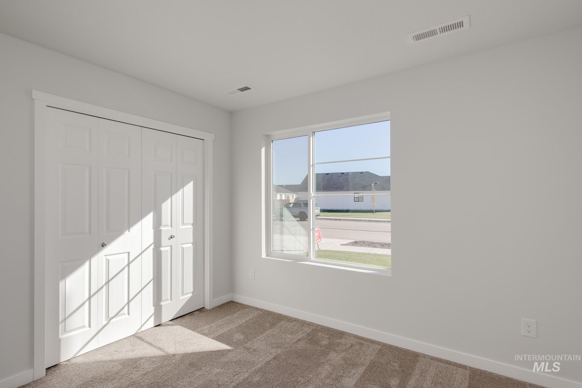 Unfurnished bedroom with light carpet and a closet