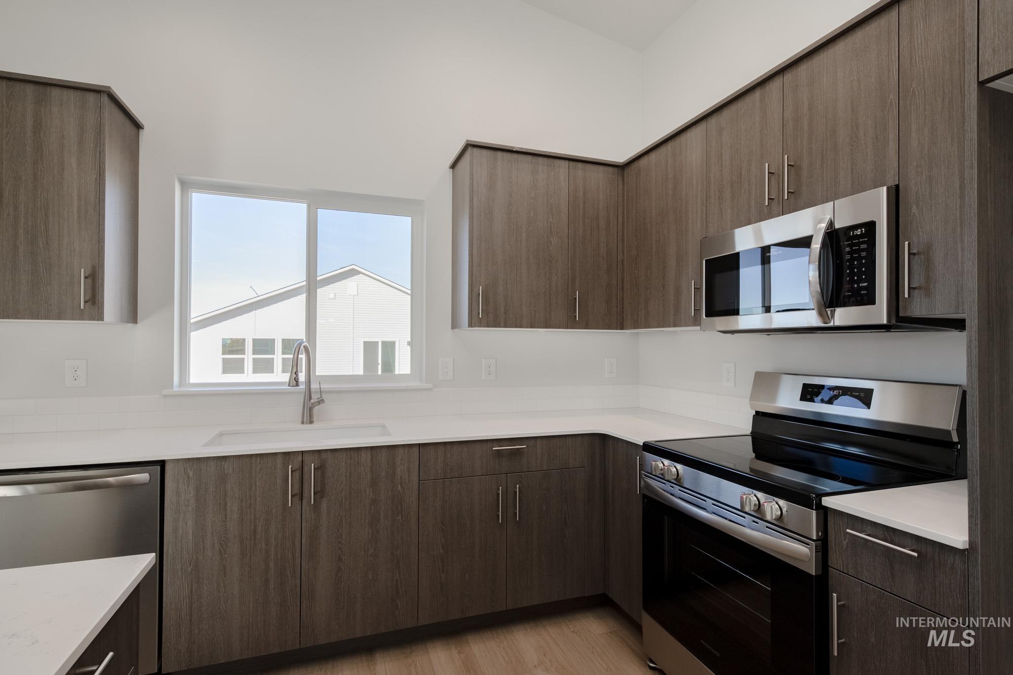 Kitchen with stainless steel appliances, modern cabinets, and light wood finished floors