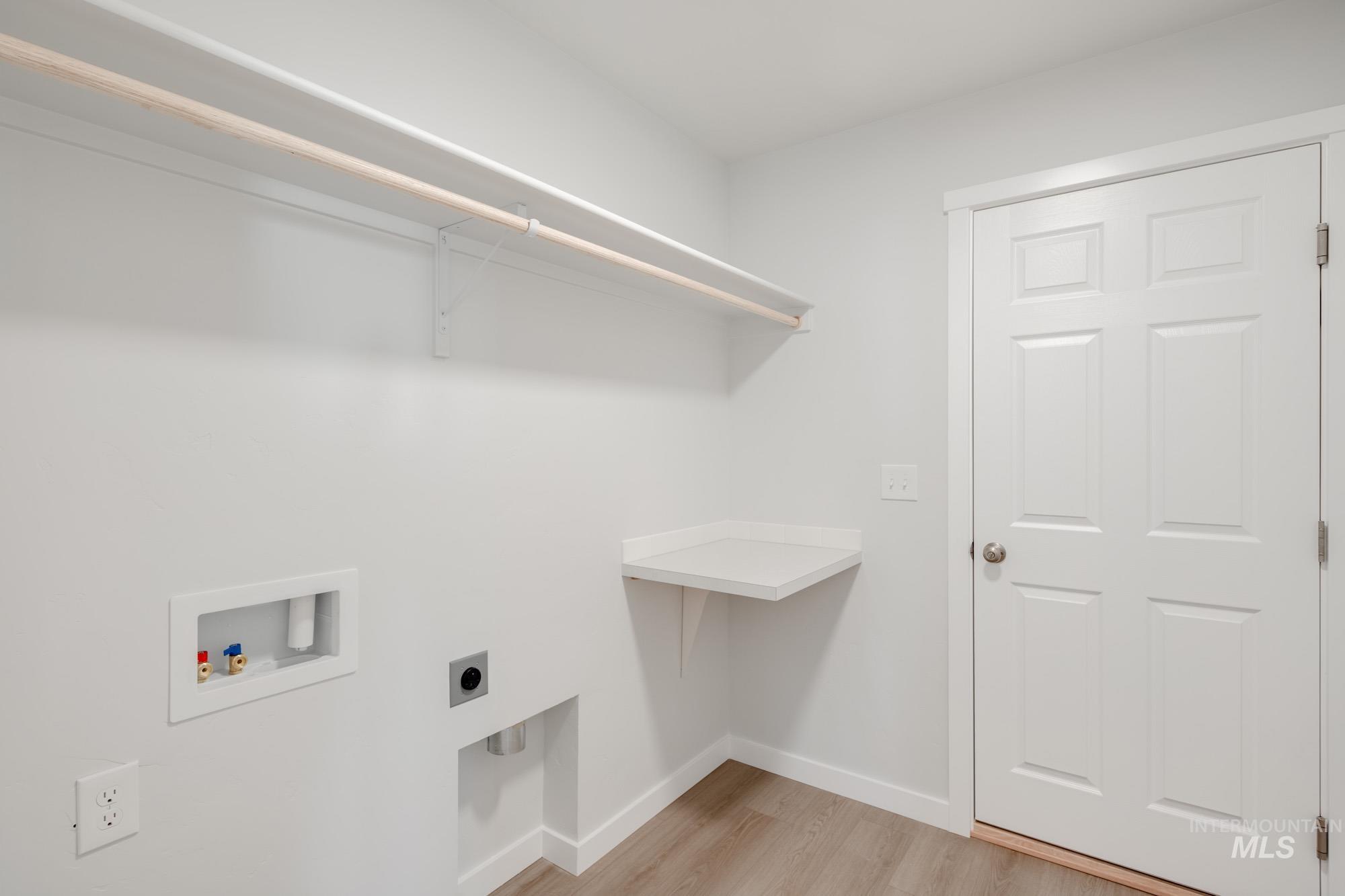Laundry room featuring light wood-type flooring, washer hookup, and electric dryer hookup