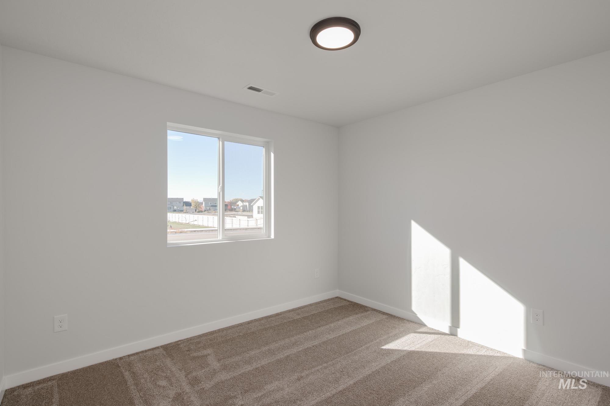 Carpeted spare room with baseboards