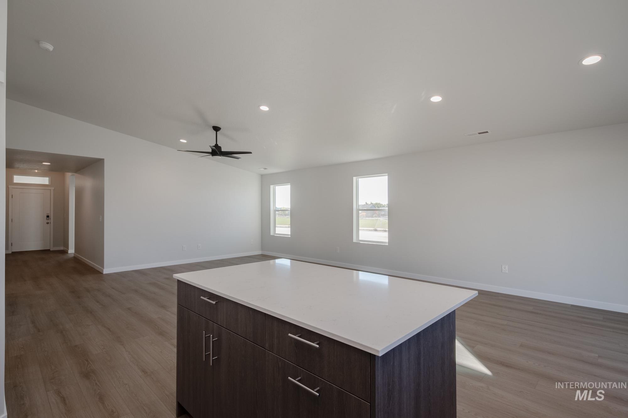 Kitchen with dark brown cabinetry, recessed lighting, a center island, light wood-style floors, and open floor plan