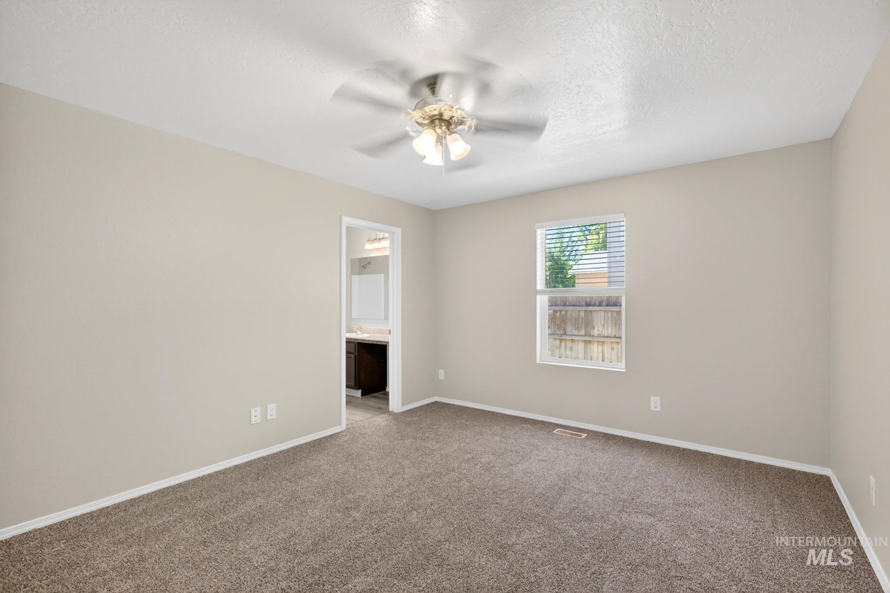 Carpeted bedroom with neutral wall tones and a ceiling fan with integrated lighting