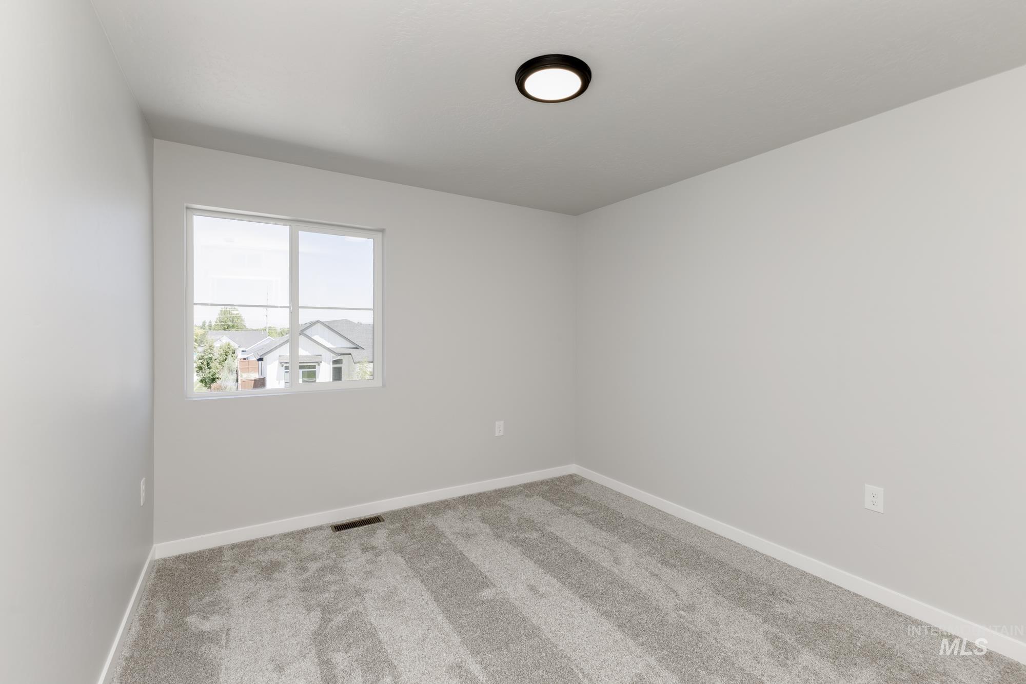 Carpeted spare room with baseboards