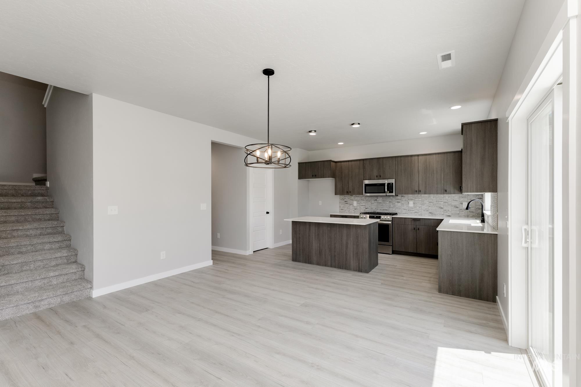 Kitchen featuring stainless steel appliances, a center island, modern cabinets, light countertops, and recessed lighting