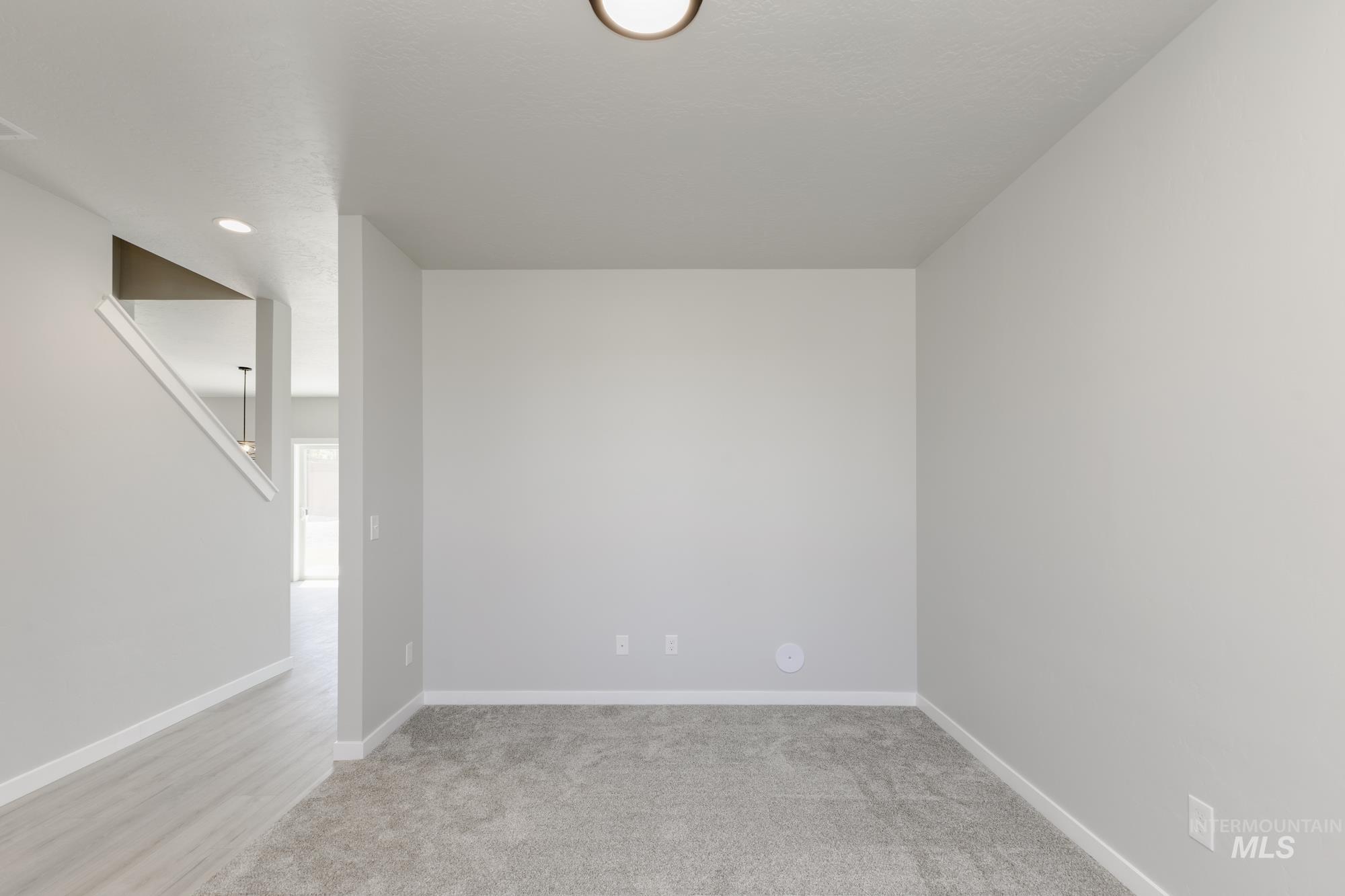 Spare room with baseboards and light carpet